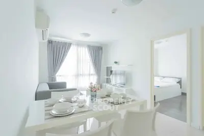 Bright and modern living room with dining area in a stylish apartment, featuring elegant decor and ample natural light.