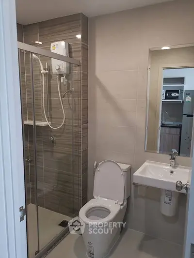 Modern bathroom with glass shower and sleek fixtures in a contemporary apartment.