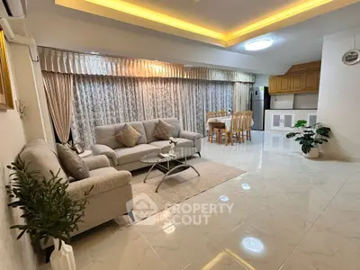 Spacious living room with elegant decor and dining area, featuring modern furniture and ambient lighting.