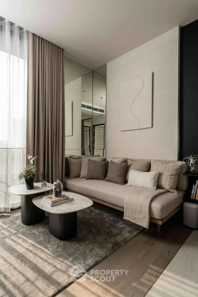 Modern living room with stylish decor, cozy sofa, and elegant coffee tables in a well-lit space.