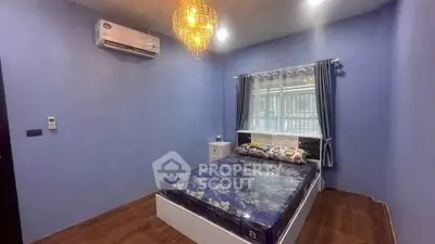 Cozy bedroom with elegant chandelier and modern air conditioning unit.