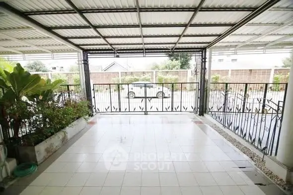 Spacious covered parking area with tiled flooring and garden view.