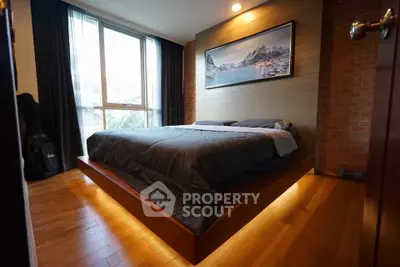 Modern bedroom with wooden flooring and large window, featuring ambient lighting and mountain artwork.