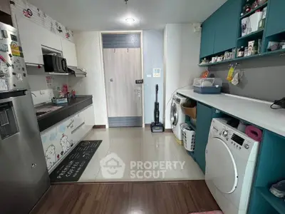 Modern kitchen with washing machine and sleek cabinetry in a stylish apartment.