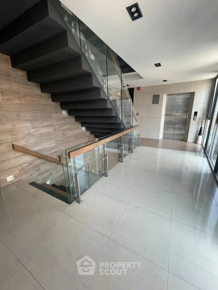 Modern building entrance with sleek staircase and elevator access