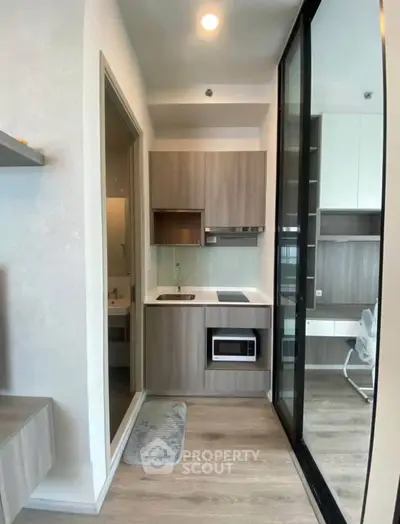 Modern compact kitchen with sleek cabinetry and integrated appliances in a stylish apartment.