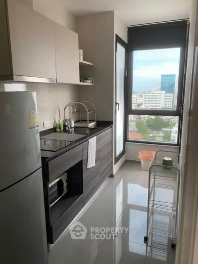 Modern kitchen with sleek design and city view, featuring built-in appliances and ample natural light.