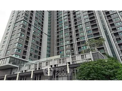 Modern high-rise building with sleek architecture and large windows in urban setting.