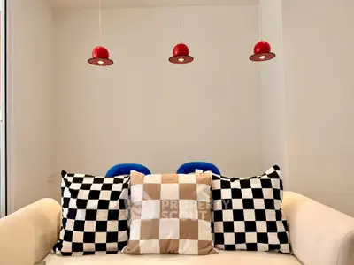 Modern living room with stylish checkered cushions and red pendant lights