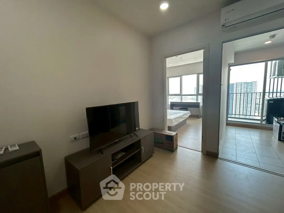 Modern apartment interior with TV, bedroom, and balcony view