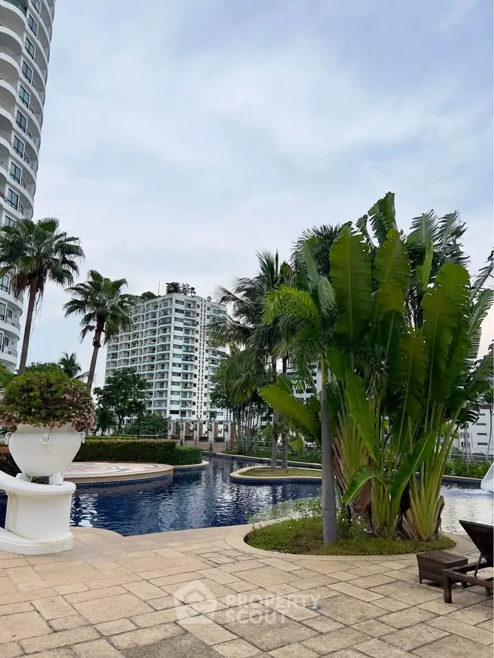 Luxurious poolside view with lush greenery and modern high-rise buildings