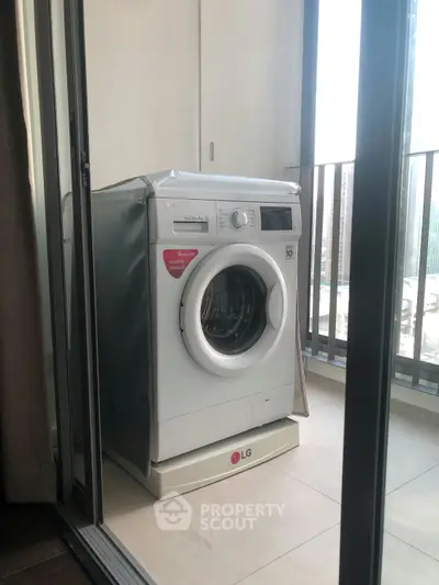Modern balcony with washing machine and city view, perfect for urban living convenience.