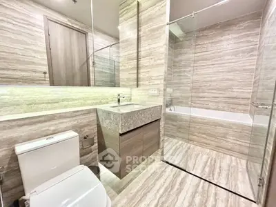 Luxurious modern bathroom with elegant marble finishes and glass shower enclosure.