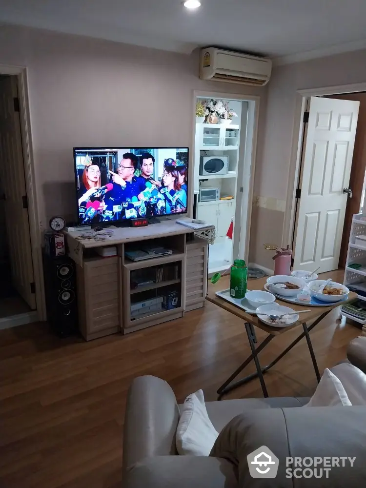 Cozy living room with wooden flooring and modern entertainment setup