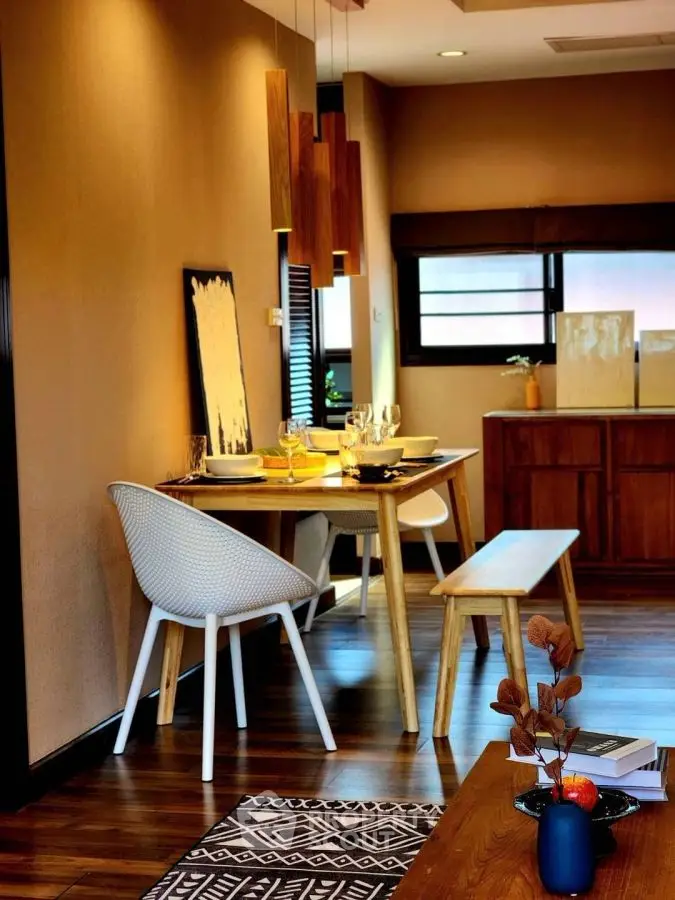 Stylish dining area with modern wooden furniture and elegant lighting in a cozy home setting.