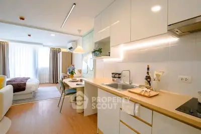 Modern open-plan studio apartment with stylish kitchen and cozy living area.