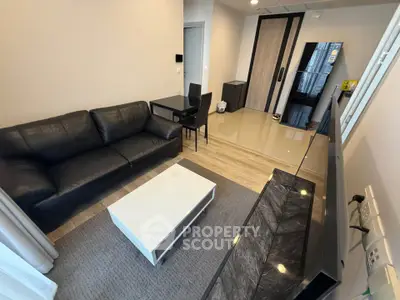 Modern living room with sleek black sofa, stylish coffee table, and elegant flooring.
