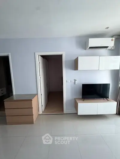 Modern living room with sleek furniture and wall-mounted TV in a stylish apartment.