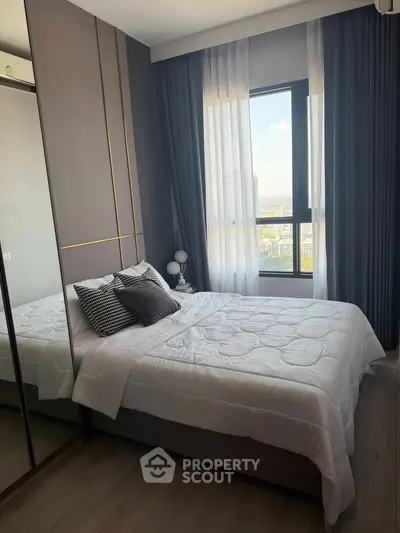 Modern bedroom with large window and stylish decor in a high-rise apartment.