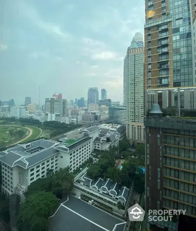 Stunning cityscape view from high-rise building with lush greenery and modern architecture.