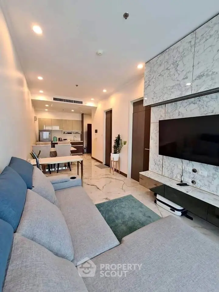 Modern living room with sleek design and open kitchen layout in a luxury apartment.