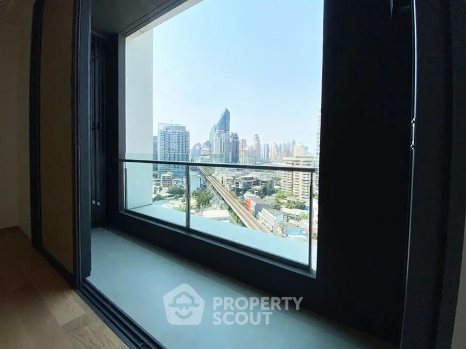 Stunning city view from modern apartment balcony with sleek glass railing.