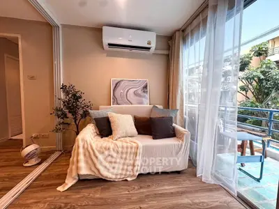 Cozy living room with air conditioning and balcony access, featuring stylish decor and natural light.