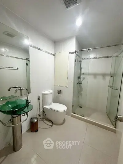 Modern bathroom with glass shower and unique glass sink design