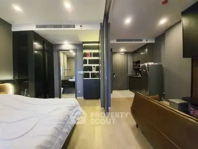 Luxurious modern studio apartment with open layout, featuring sleek kitchen and cozy living area.