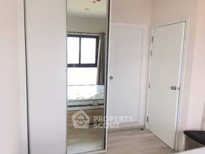 Modern bedroom with mirrored closet doors and natural light