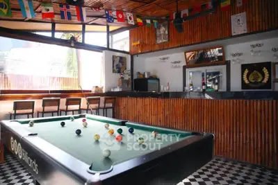 Stylish game room with pool table and bar area, perfect for entertainment.