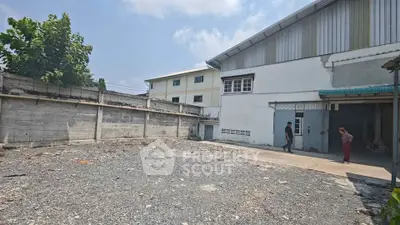 Spacious industrial property with ample outdoor space and secure fencing, ideal for business operations.