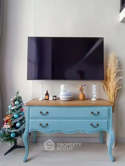 Charming living room with vintage blue console table and wall-mounted TV, perfect for cozy home decor.