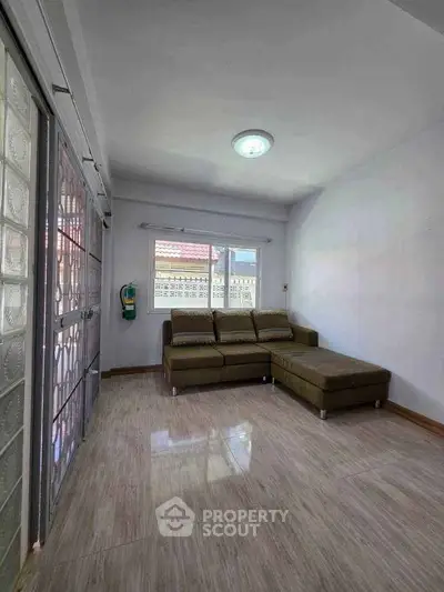 Spacious living room with modern sofa and large windows for natural light.