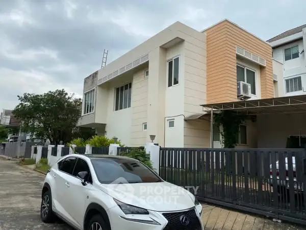Modern two-story house with sleek design and luxury car parked in front