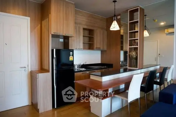 Modern kitchen with wooden cabinets and dining area in stylish apartment