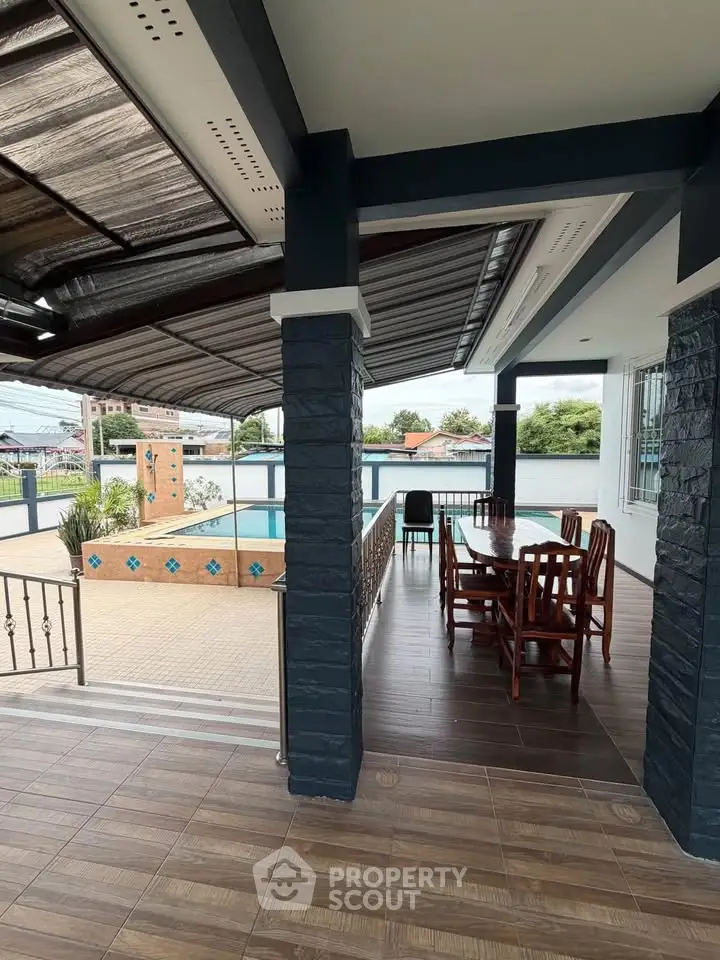 Spacious outdoor area with pool and dining set, perfect for relaxation and entertainment.