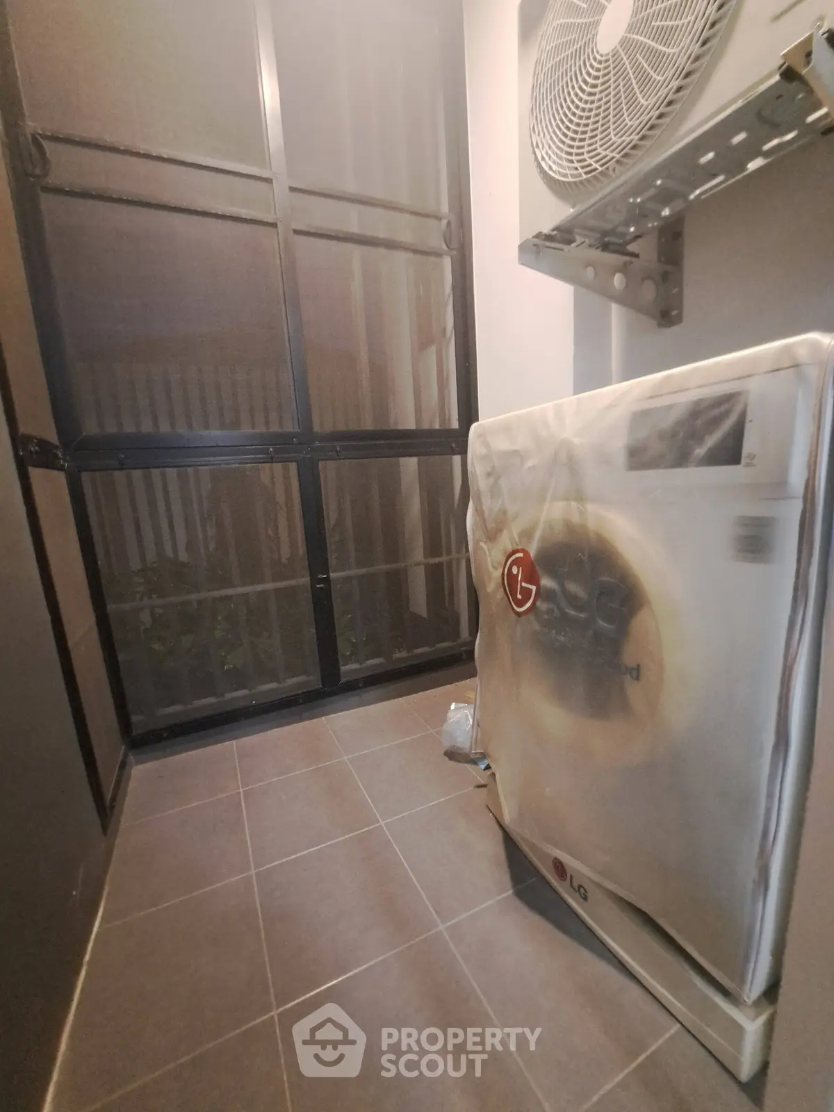 Modern laundry area with large window and new washing machine in sleek apartment.