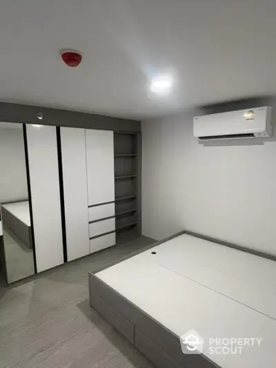 Modern minimalist bedroom with built-in wardrobe and air conditioning unit