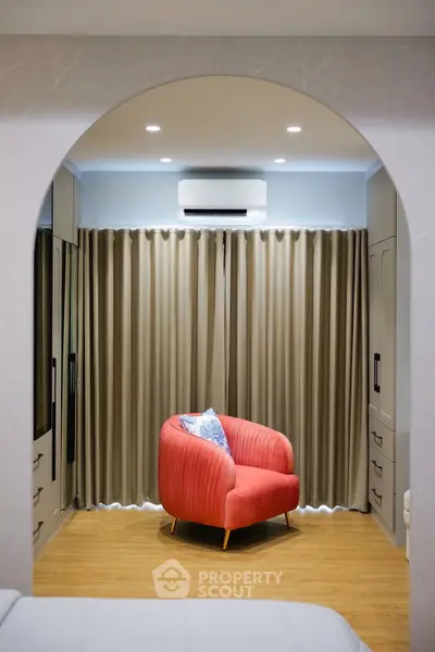 Stylish bedroom with modern decor and cozy armchair under soft lighting