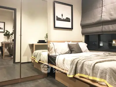 Modern bedroom with stylish decor and large mirror reflecting cozy ambiance.