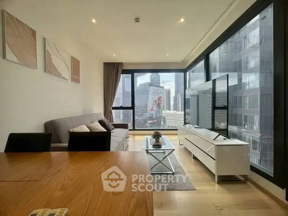 Modern living room with city view, featuring sleek furniture and large windows for natural light.