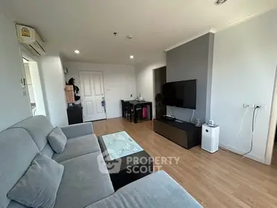 Modern living room with sleek furniture and wooden flooring, perfect for cozy gatherings.