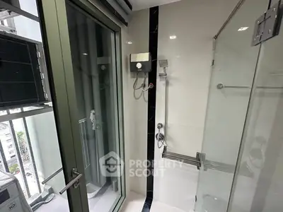 Modern bathroom with glass shower and balcony view in high-rise apartment