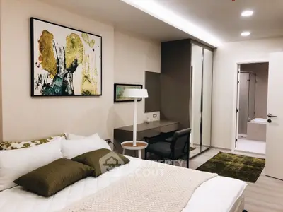 Modern bedroom with stylish decor and ensuite bathroom, featuring a cozy bed and contemporary artwork.