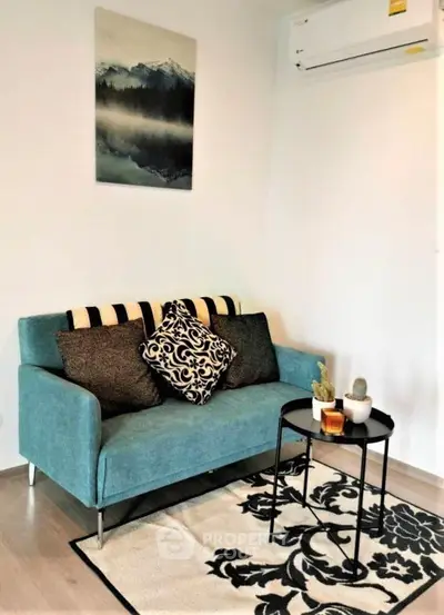 Cozy living room with stylish sofa, decorative cushions, and modern wall art.