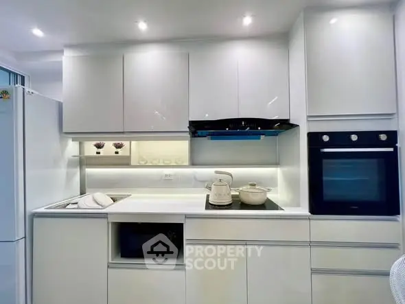 Modern kitchen with sleek white cabinets and built-in appliances