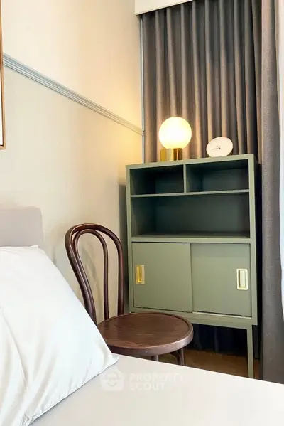 Cozy bedroom corner with stylish cabinet and elegant chair, perfect for modern living.