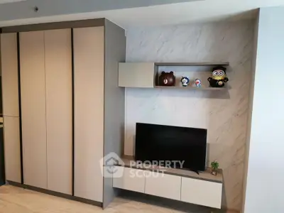 Modern living room with sleek storage and TV unit, featuring stylish decor and open shelving.