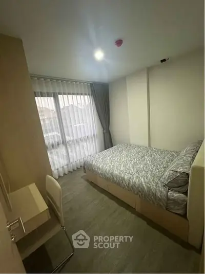 Cozy bedroom with modern decor and large window for natural light